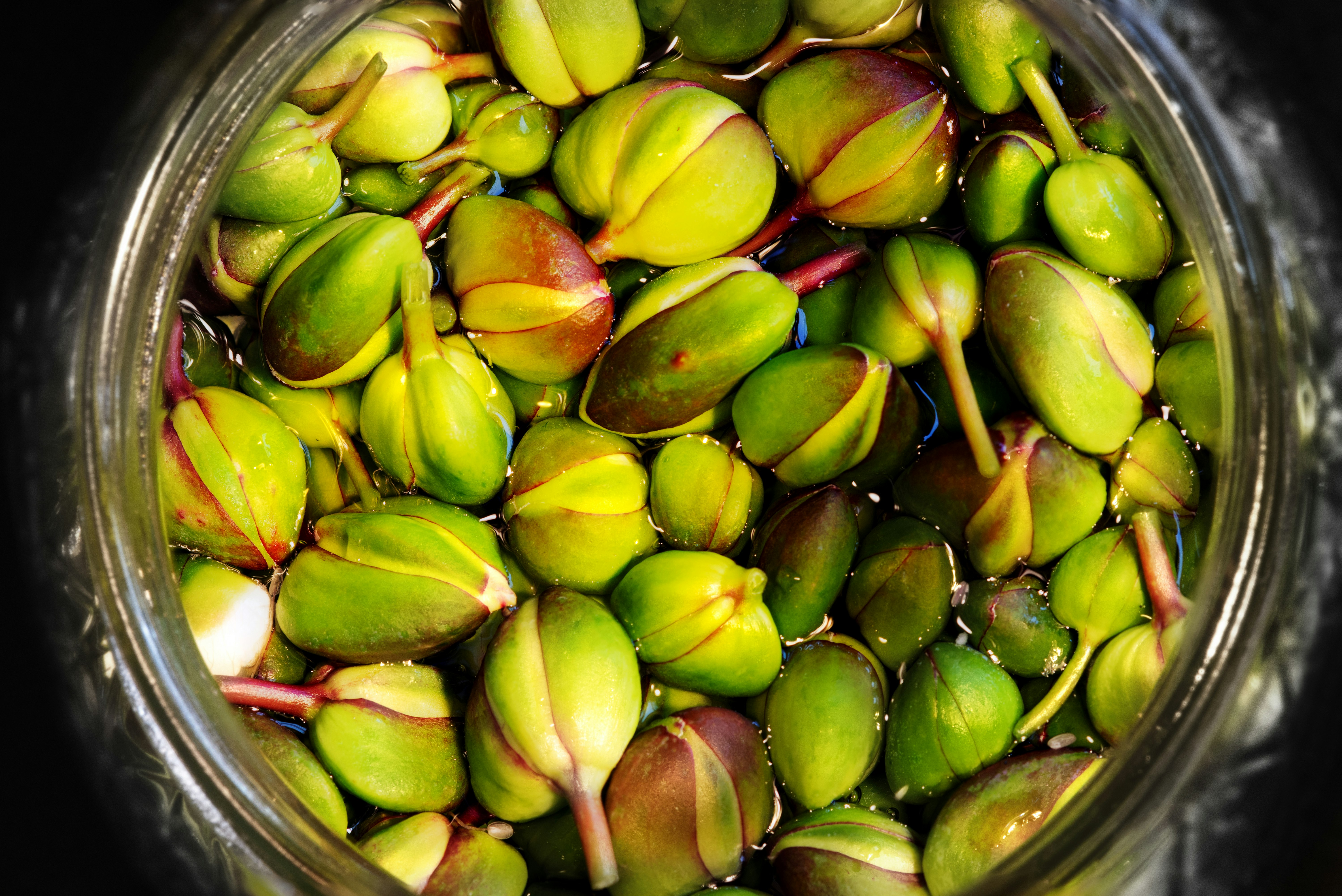 green and brown fruit on clear glass bowl